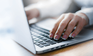 Close-up of a person’s hands typing on a laptop keyboard, with a shallow depth of field—a scene familiar to physical therapists Bergen County NJ, who help patients recover from repetitive strain or hand injuries.